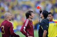 Chilean referee Enrique Osses shows a re