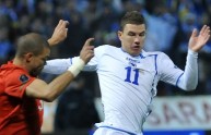 Bosnia’s Edin Dzeko (R) vies for ball wi